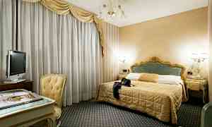 Et hotellrom med en dobbeltseng, et skrivebord med stol og en TV. (AI-generert tekst)