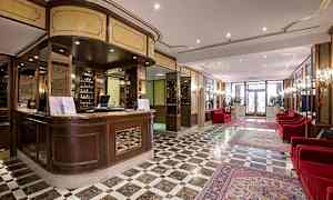 Resepsjon og lobbyområde med marmorgulv og røde sofaer. (AI-generert tekst)