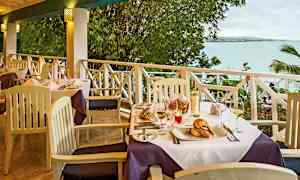 Et dekket bord på en terrasse med utsikt over havet. (AI-generert tekst)