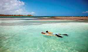 To personer snorkler i turkis vann. (AI-generert tekst)