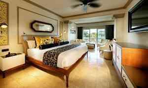 Et hotellrom med en dobbeltseng, innbydende sittegruppe og balkong med utsikt. (AI-generert tekst)