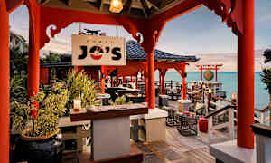 Bilde av en restaurant med asiatisk interiør ved havet. (AI-generert tekst)