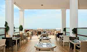 Restaurant med utemøbler og havutsikt. (AI-generert tekst)