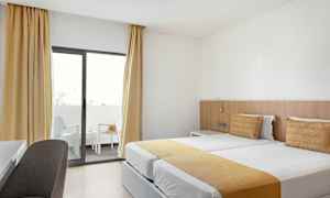 Hotellrom med to enkeltsenger og balkong. (AI-generert tekst)