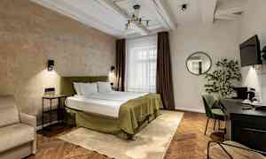 Et hotellrom med en dobbeltseng, nattbord, en skrivebordskrok og et speil på veggen. (AI-generert tekst)