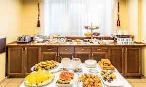 Hotellfrokostbuffé med ulike retter, inkludert frukt, bakverk og drikke. (AI-generert tekst)