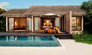 En strandvilla med privat basseng og sittemøbler på en terrasse av tre. (AI-generert tekst)