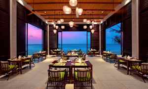 Bilde av en restaurant med havutsikt og fargerik kveldshimmel. (AI-generert tekst)