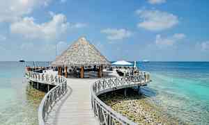 En trebro fører til en hytte ved havet. (AI-generert tekst)