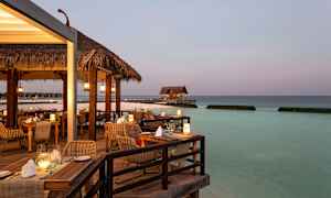 En restaurant med utsikt over havet på kveldstid. (AI-generert tekst)