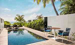 Privat basseng på en terrasse med solsenger og havutsikt. (AI-generert tekst)