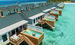 Bungalower på stylter med private små bassenger over klart turkis vann. (AI-generert tekst)