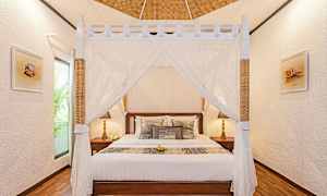 Et soverom med en himmelseng og dekorative puter. (AI-generert tekst)