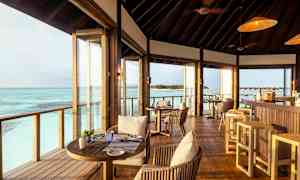 Interiør av en restaurant med utsikt over havet. (AI-generert tekst)