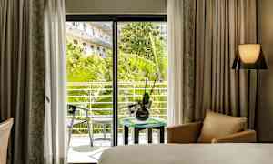 Hotellrom med utsikt mot en frodig balkong. (AI-generert tekst)