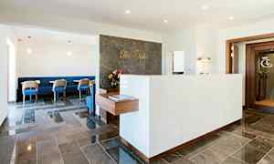 En resepsjon med en marmordisk og stoler i en lounge. (AI-generert tekst)