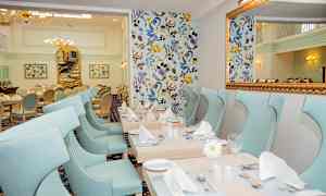 En elegant spisesal med lyseblå stoler og dekorative bord. (AI-generert tekst)