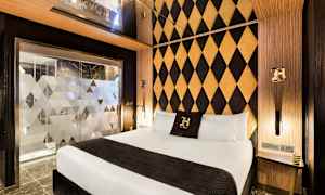 Hotellrom med moderne innredning, dobbeltseng og dekorativt mønstrede vegger. (AI-generert tekst)