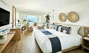 Et lyst og moderne hotellrom med utsikt over havet. (AI-generert tekst)