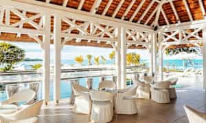 Utsikt over en terrasse med hvite møbler og havet i bakgrunnen. (AI-generert tekst)