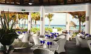 Restaurant med hvite flettede møbler under tak med utsikt over havet og palmetrær. (AI-generert tekst)