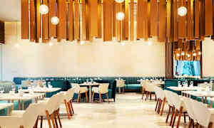 En moderne restaurant med elegante stoler og bord. Dekorative lys henger fra taket. (AI-generert tekst)