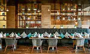 Restaurantmiljø med bord, stoler og veggdekorasjoner med hyller. (AI-generert tekst)