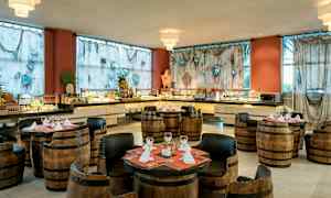 Et restaurantområde med karstoler og bord, omgitt av en buffet og dekorerte gardiner. (AI-generert tekst)