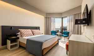 Moderne hotellrom med dobbeltseng, sittegruppe og utsikt. (AI-generert tekst)