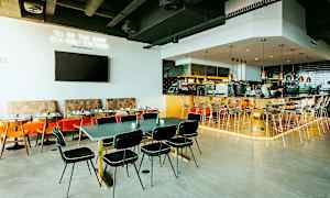 Restaurantinteriør med bord, stoler og en bardisk. (AI-generert tekst)