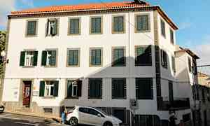 Bygning med hvite vegger, grønne skodder og rødt takstein. (AI-generert tekst)