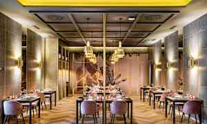 Bilde av en elegant restaurant med bord og stoler, moderne innredning og stemningsfull belysning. (AI-generert tekst)