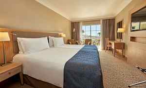 Hotellrom med to enkeltsenger og en balkong med utsikt. (AI-generert tekst)