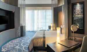 Hotellrom med moderne interiør, seng og skrivebord. (AI-generert tekst)