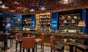 Interiør av en elegant bar med sitteplasser og dekorert tak. (AI-generert tekst)