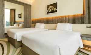 Hotellrom med to enkeltsenger, moderne innredning og lyse farger. (AI-generert tekst)