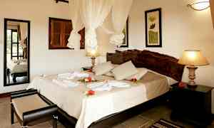 Hotellrom med dobbeltseng, dekorert med blomster og håndklær. (AI-generert tekst)