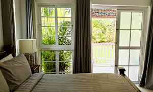 Et soverom med vindu og dør som vender ut mot en hage. (AI-generert tekst)