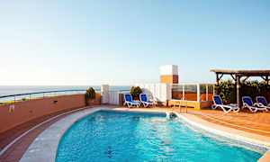 Utendørs basseng med solsenger og havutsikt. (AI-generert tekst)