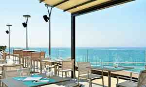 Terrasse med sitteplasser og utsikt over havet. (AI-generert tekst)