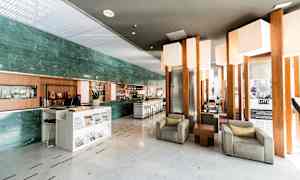 En hotellobby med sittegrupper og en resepsjonsdisk. (AI-generert tekst)