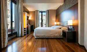 Et moderne soverom med en stor seng og store vinduer som slipper inn mye lys. (AI-generert tekst)