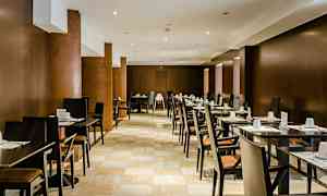 Et restaurantområde med rekker av bord og stoler, dekket for gjester. (AI-generert tekst)