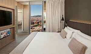 Et hotellrom med en stor seng med hvitt sengetøy og beige puter, moderne design med et TV-skap, magasiner og et vindu som viser en byutsikt. (AI-generert tekst)