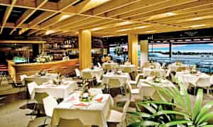 Restaurantinteriør med dekkede bord og dekorative blomster. (AI-generert tekst)