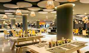 Elegant restaurant med moderne innredning, med benker og bord dekorert med små planter. (AI-generert tekst)