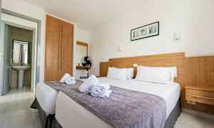 Dobbeltrom med en seng, tredetaljer og hvite vegger. (AI-generert tekst)