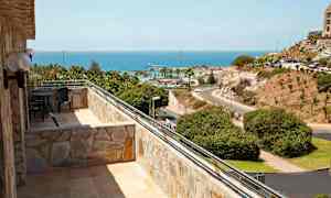 Bilde av en balkong med utsikt over havet og landskapet. (AI-generert tekst)