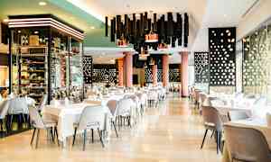 Elegant hotellrestaurant med dekkede bord og moderne interiør. (AI-generert tekst)