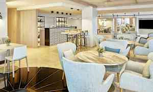 Interiør av en moderne kafé med lyse møbler og en bardisk. (AI-generert tekst)